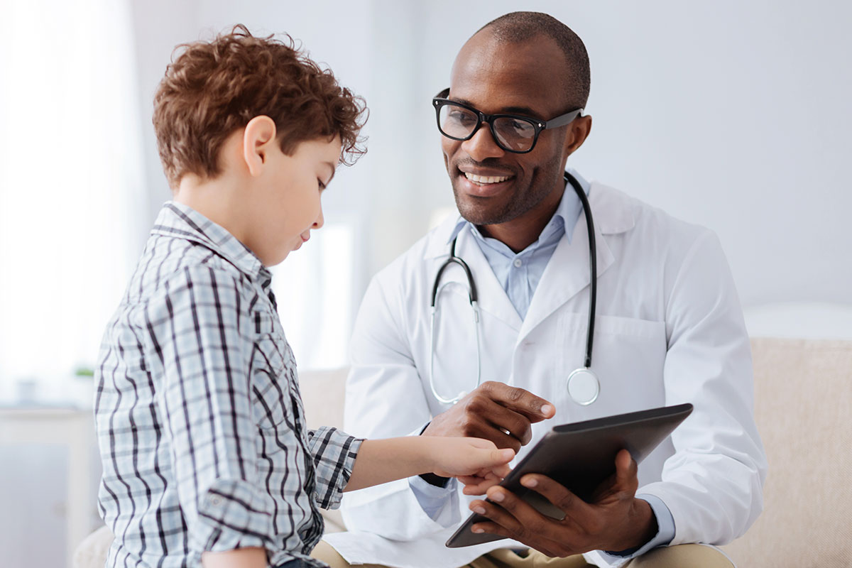 Doctor showing a young boy his tablet